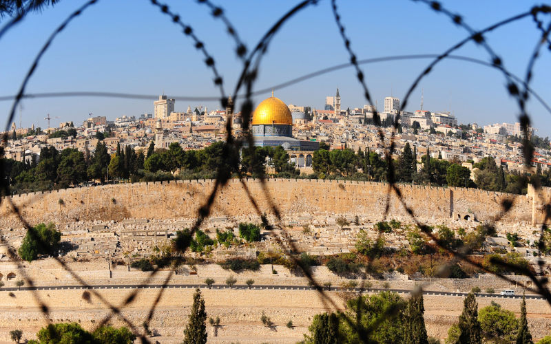 View from the Mount of Olives on the dome of the rock and ancient cemetery through the barbed wire, as a symbol of Palestine Israeli conflict,