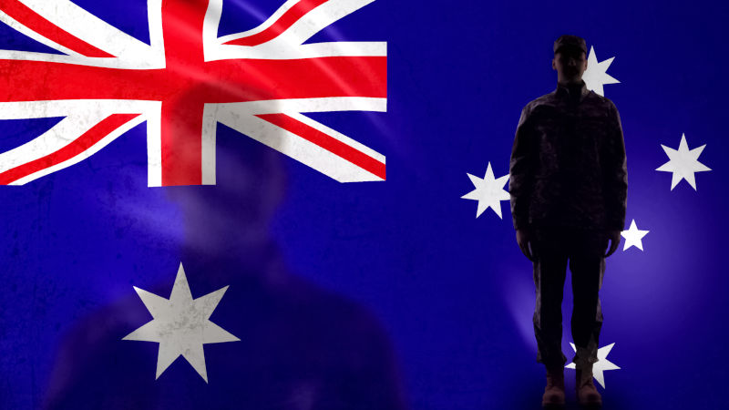 Australian soldier silhouette standing against national flag.