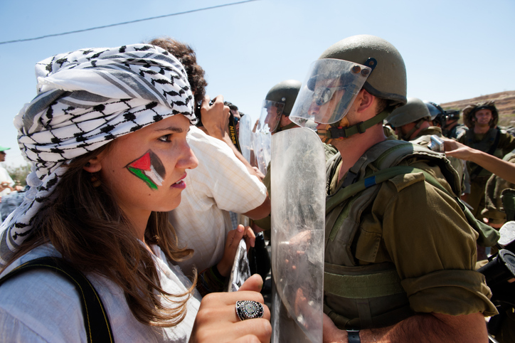 Al-Masara, Occupied Palestinian Territories - August 24, 2012: Italian solidarity activists join Palestinians confronting heavily armed Israeli soldiers in a weekly nonviolent demonstration against the separation barrier that would cut off the West Bank village of Al Ma'sara from its agricultural lands.