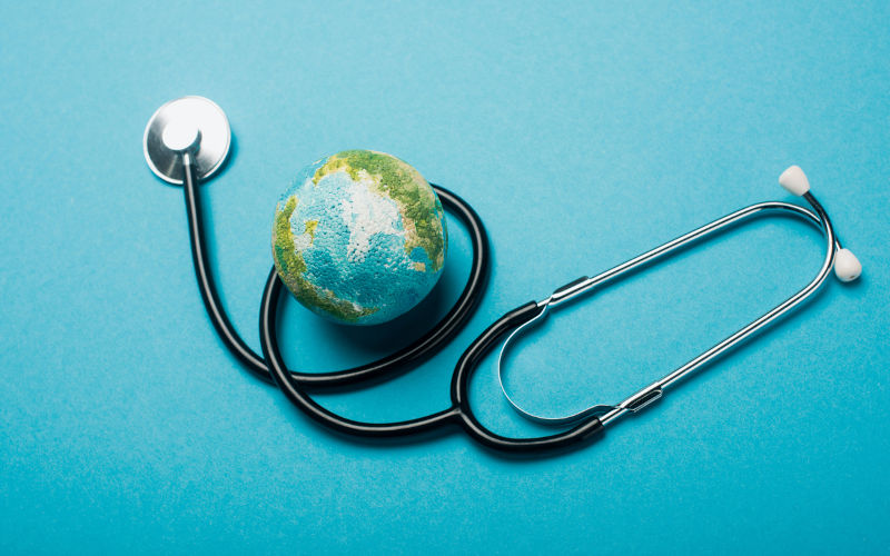 Globe and stethoscope on blue background.