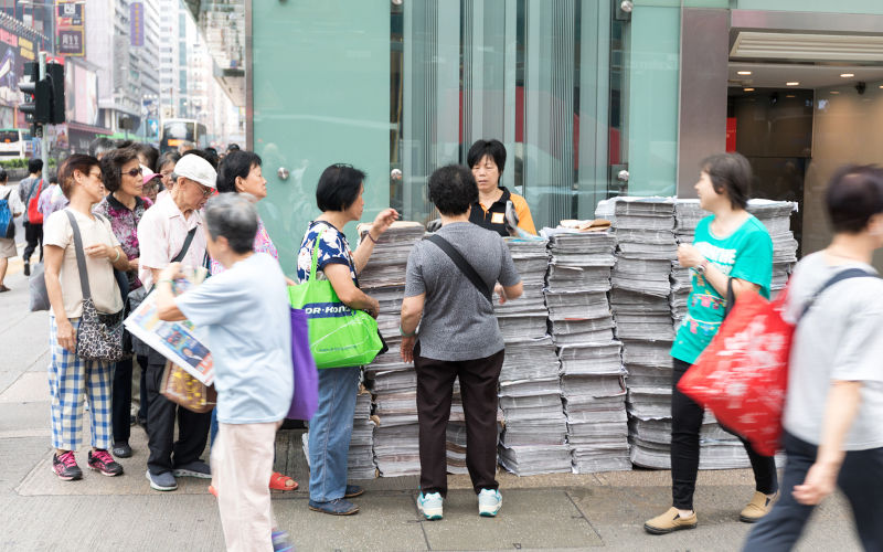 KOWLOON, HONG KONG People Waiting in Line For Newspapers at Nathan Road Mong Kok in Kowloon, Hong Kong.