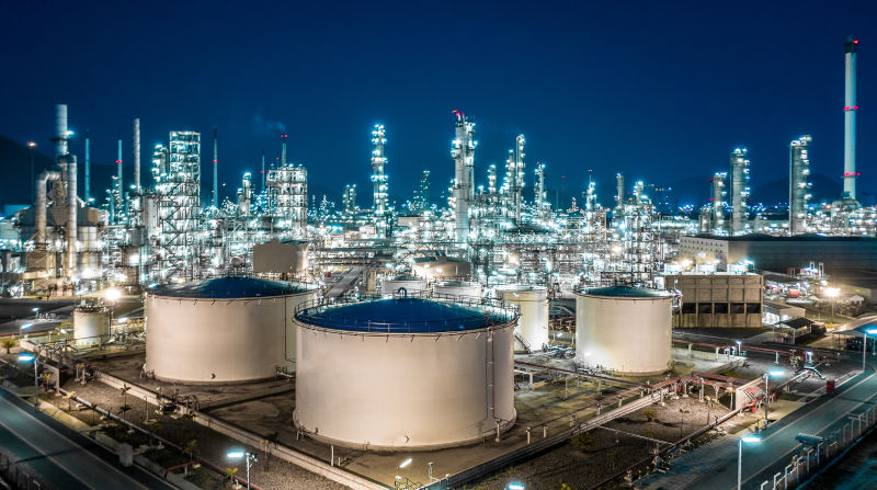 Oil refinery plant from industry zone, Aerial view oil and gas industrial, Refinery factory oil storage tank and pipeline steel at night.