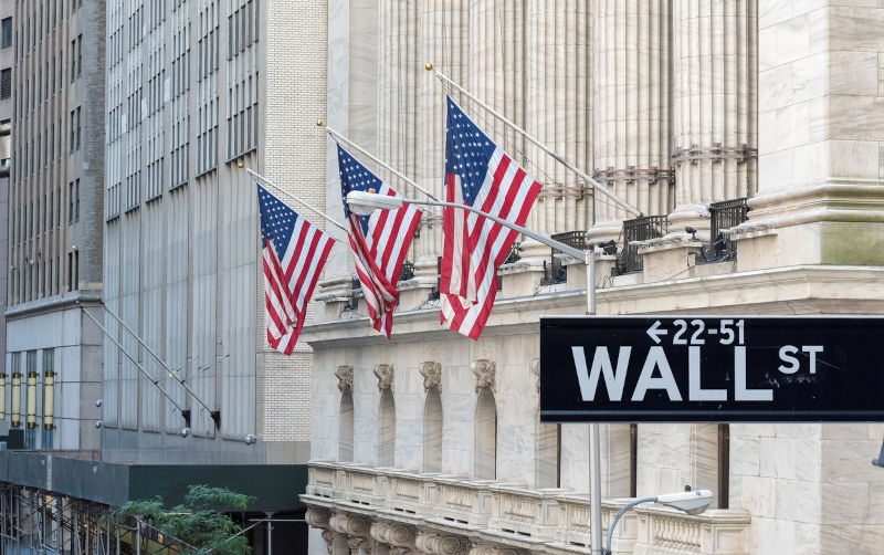 Wall street sign in New York City with New York Stock Exchange.