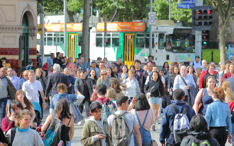 Melbourne Australia - December 3, 2018: Unidentified people cross street in downtown Melbourne Australia.