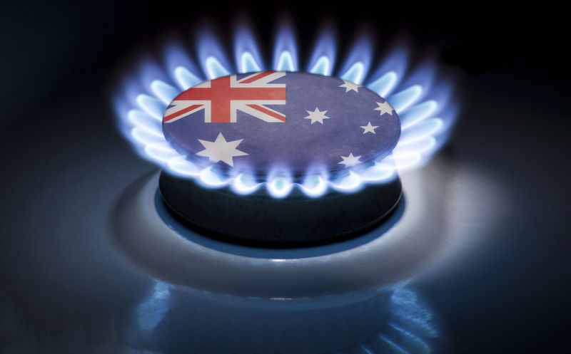 Burning gas burner of a home stove in the middle of which is the flag of the country of Australia. Gas import and export delivery concept,