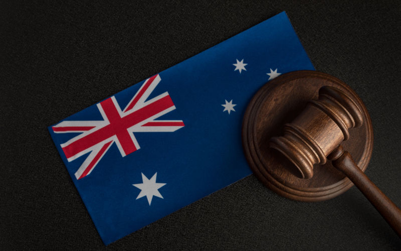 Court-in-Australia. Image: iStock / SomeMeans Judge gavel near the Australian flag. Court in Australia.