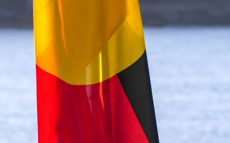 The Australian Aboriginal flag on a flagpole at Bondi Beach, Sydney.