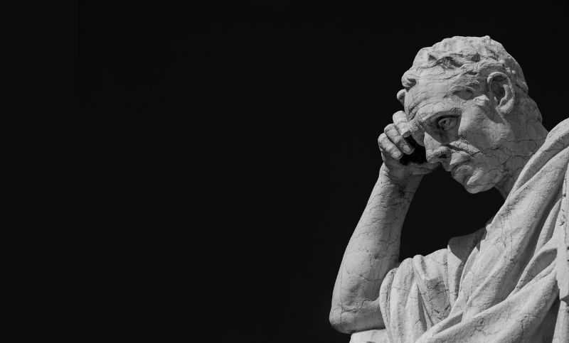 Man statue in the act of thinking against blue sky. Ancient Roman Julian the Jurist statue made at the end of 19th century in front of the Old Palace of Justice in Rome