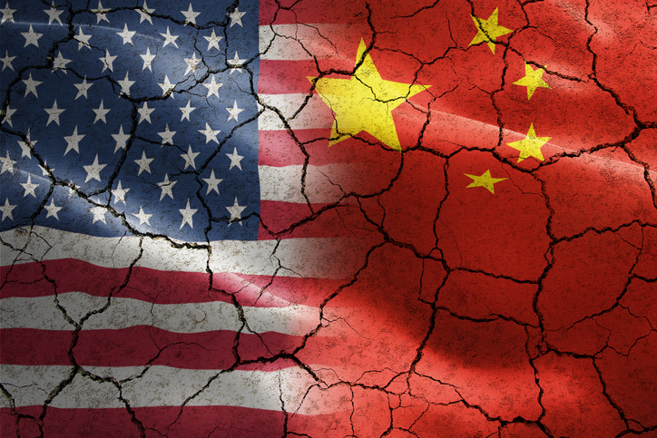 Flag of United States of America against China in cracked texture - indicates negative impact and conflict between these two countries such as international economy, trade war, partnership. Image: iStock / twinsterphoto