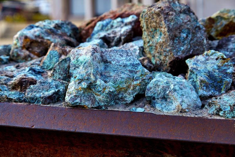 Chunks of copper ore mineral rocks in an iron barrel.