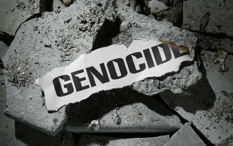 Paper with word Genocide on pieces of concrete, top view